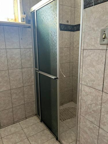 a shower with a glass door in a bathroom at CasaZita in Passo De Torres