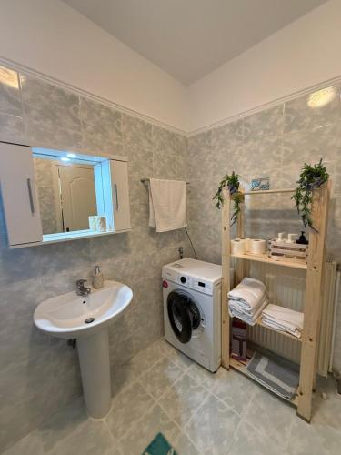 a bathroom with a sink and a washing machine at Summer Comfort Apartment in Nea Kallikrateia