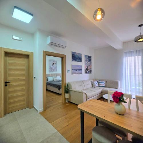 a living room with a couch and a table at Olive residence A8 in Petrovac na Moru