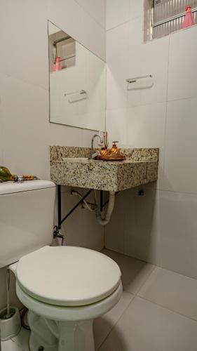 a white bathroom with a toilet and a sink at Vila Fox Estadia in Lençóis