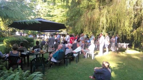 a group of people sitting at tables in a garden at Mountain View Holiday Retreat in Harrietville
