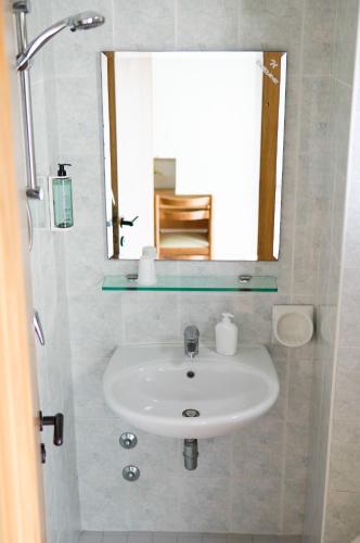 ein weißes Waschbecken in einem Badezimmer mit Spiegel in der Unterkunft Hotel Euromar in Rimini
