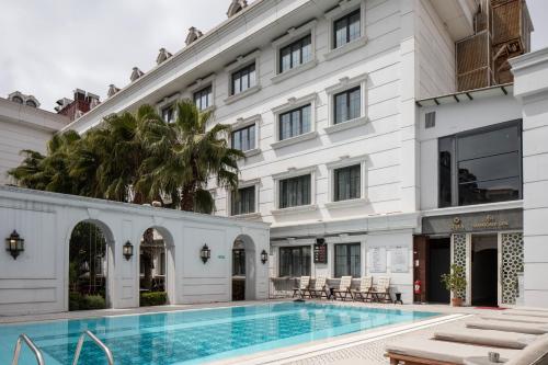 ein Hotel mit einem Schwimmbad vor einem Gebäude in der Unterkunft Sura Design Hotel & Suites in Istanbul