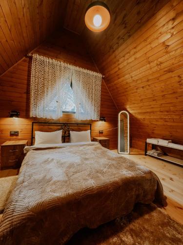 a bedroom with a large bed in a wooden room at Omenor Kazbegi in Kazbegi