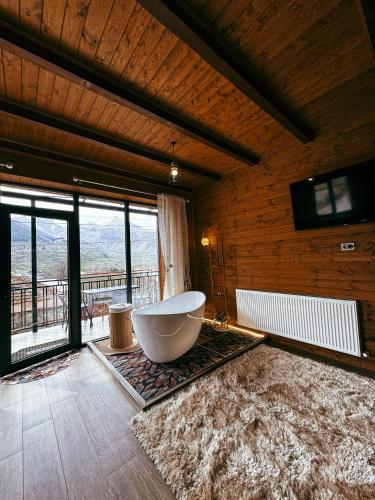 a large bathroom with a tub and a large window at Omenor Kazbegi in Kazbegi