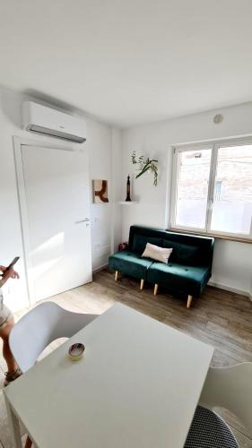 a living room with a green couch and a table at Catia's Apartments, Clima, Mare&Spiaggia 700mt in Porto San Giorgio
