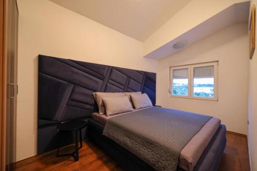 a bedroom with a large bed with a large headboard at Apartmani Novia in Bibinje
