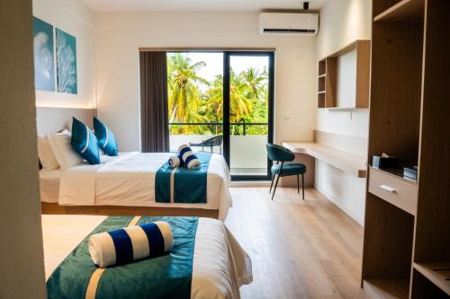 a hotel room with two beds and a window at Kashiveli Omadhoo in Omadhoo