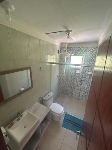 a bathroom with a toilet and a sink and a shower at COBERTURA Duplex com Visao do Mar, Village das ondas in Piúma