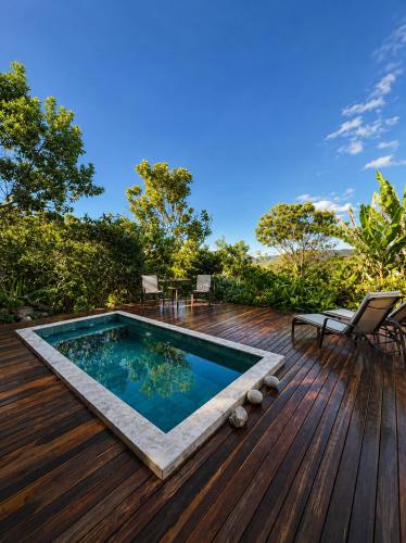 a wooden deck with a swimming pool on top of it at Pariká Pousada in Alto Paraíso de Goiás