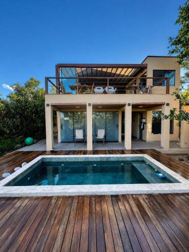 a house with a swimming pool on a wooden deck at Pariká Pousada in Alto Paraíso de Goiás