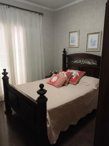 a bedroom with a large bed with red pillows at Harmonia e Paz in São José dos Campos