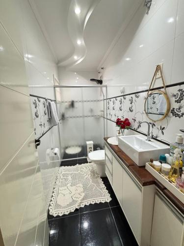 a white bathroom with a sink and a toilet at Harmonia e Paz in São José dos Campos