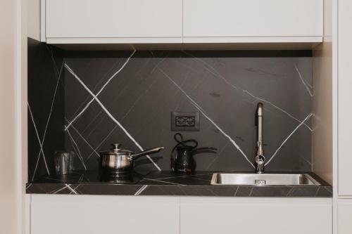 a kitchen sink with pots and pans on it at Shehu Skenderbeg Stay in Tirana