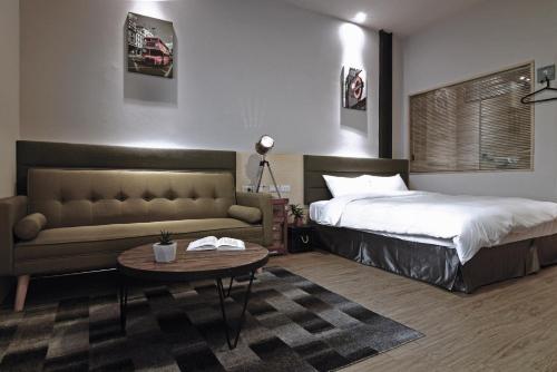a bedroom with a bed and a couch and a table at 日月潭 3JD home 一館 in Yuchi