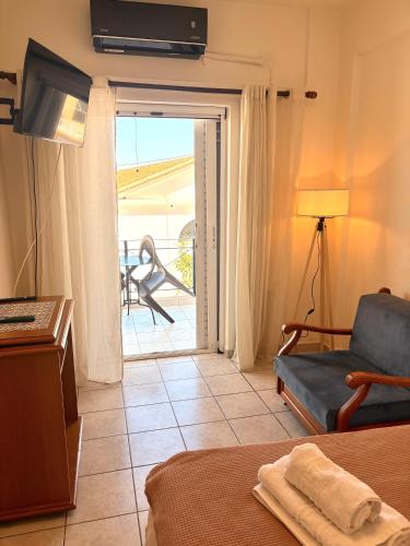 a living room with a couch and a sliding glass door at Port Breeze Apartments in Karlovasi