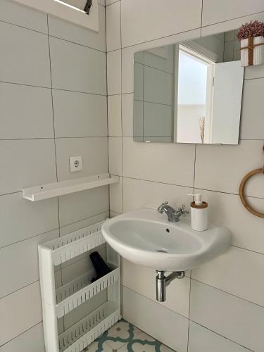 a white bathroom with a sink and a mirror at Elvas Centro Histórico Largo do Refúgio in Elvas