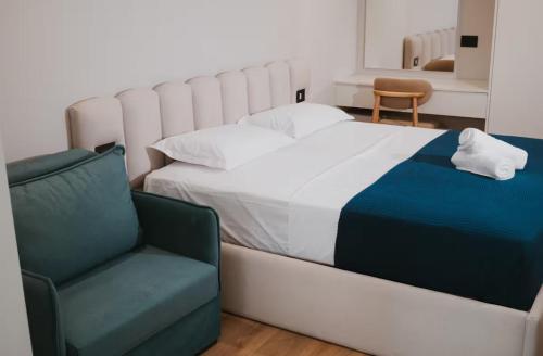 a bedroom with a large bed and a chair at Shehu Skenderbeg Stay in Tirana