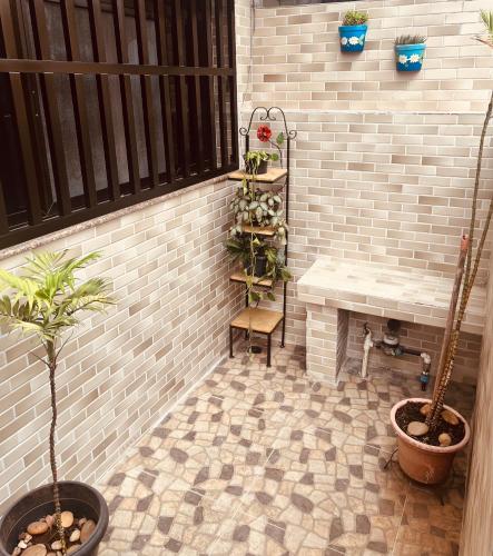 a patio with a bench and potted plants at Casa na Ponta da Praia - Quintais privativos, churrasqueira e Wi-fi - Até 6 hospedes in Santos