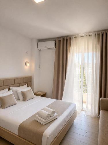 a bedroom with a large bed with towels on it at Zador Hotel in Ksamil