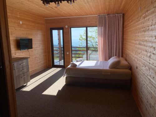 a bedroom with a bed and a large window at SUNSET BUKNARI in Buknari