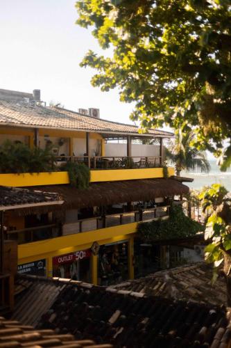 a yellow building with a restaurant on top of it at Pousada Funny in Morro de São Paulo
