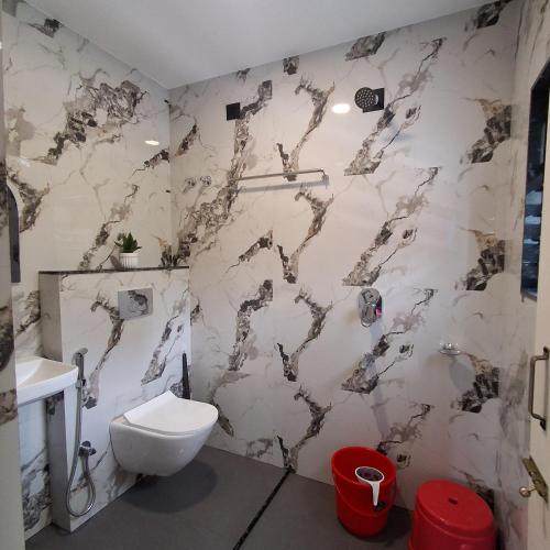 a white bathroom with a toilet and a sink at Royal Homestay Siliguri in Silīguri Junction