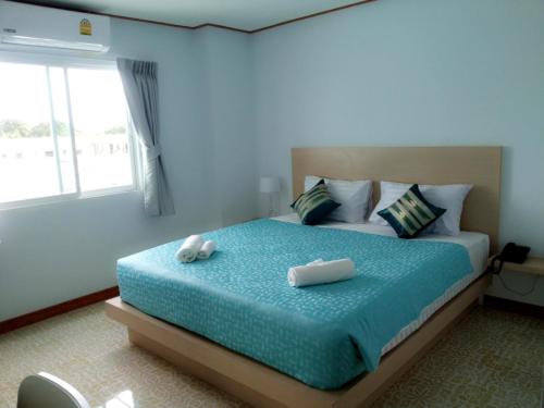 a bedroom with a bed with two towels on it at The Duck in Phuket Town