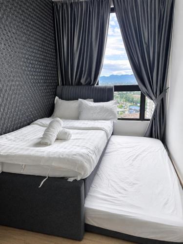 a bedroom with two beds in front of a window at Piccadilly Residence by LMS ipoh in Ipoh