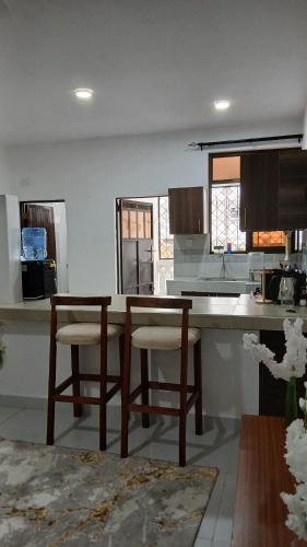 a kitchen with two chairs and a table in it at Imani staycations Diani 2 in Diani Beach