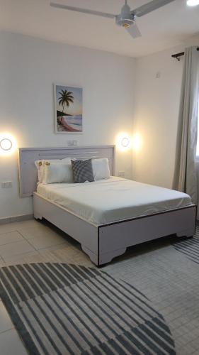 a white bedroom with a large bed in a room at Imani staycations Diani 2 in Diani Beach