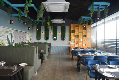a dining room with tables and blue chairs at Grand Savera in Saharsa