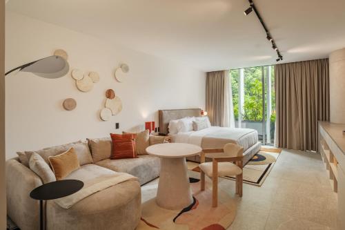 a living room with a couch and a bed and a table at Nomu Mexico City by Lumina in Mexico City
