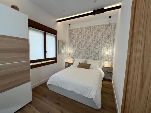 a bedroom with a white bed and a window at Tentietxea in Areatza