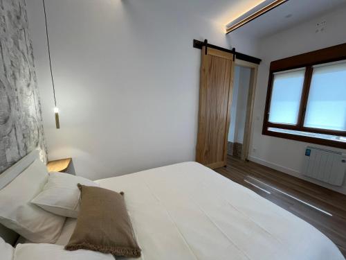 a bedroom with a white bed and a window at Tentietxea in Areatza
