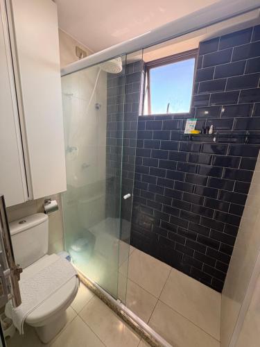 a bathroom with a toilet and a glass shower at STUDIO Mar azul 1206 in São Luís