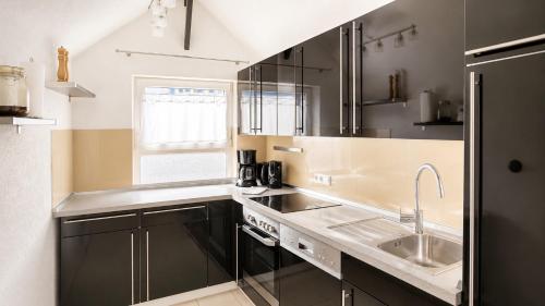 a kitchen with stainless steel appliances and a sink at Haus OS in Bischofshofen