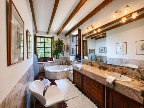 a bathroom with two sinks and a tub at La Rayuela Suites Boutique in Frontera