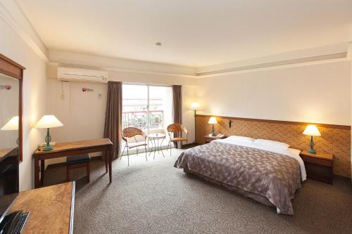 a hotel room with a bed and a desk at Hoya Hotel in Wenquan