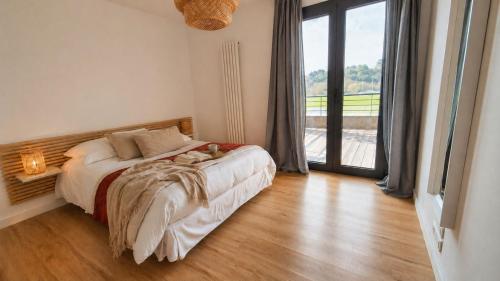 a bedroom with a bed and a large window at Lodge Marie in Villegailhenc