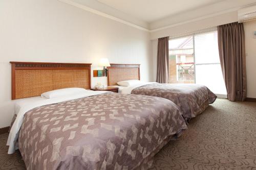 a hotel room with two beds and a window at Hoya Hotel in Wenquan