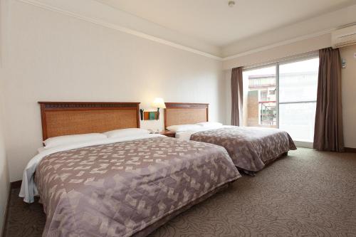 a hotel room with two beds and a large window at Hoya Hotel in Wenquan