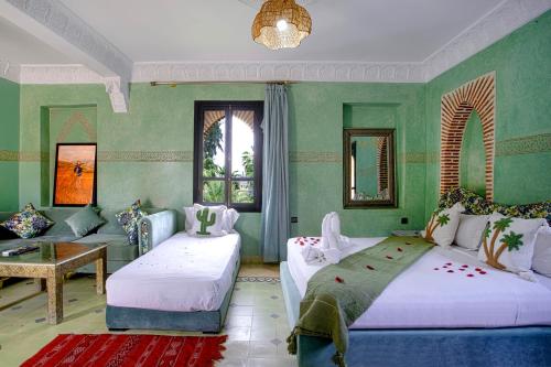 a green room with two beds and a couch at Domaine Ghait in Had Abdallah Rhiat