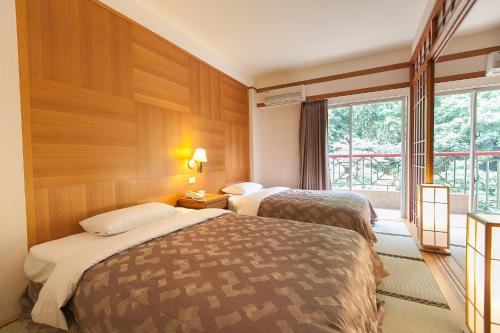 a hotel room with two beds and a window at Hoya Hotel in Wenquan