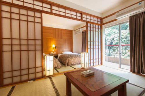 溫泉村的住宿－富野大飯店，客房设有床、桌子和窗户。