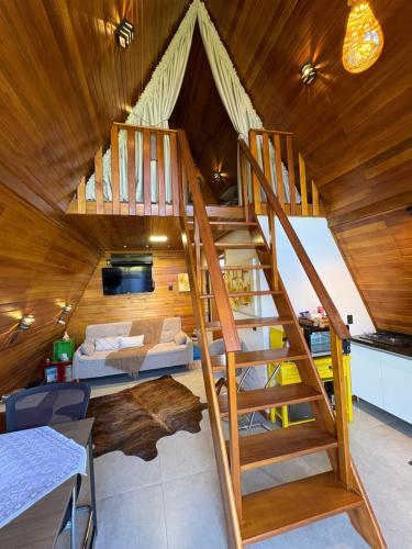 a room with a spiral staircase in a tiny house at Sítio das Amoreiras- Cabana in Tabapira