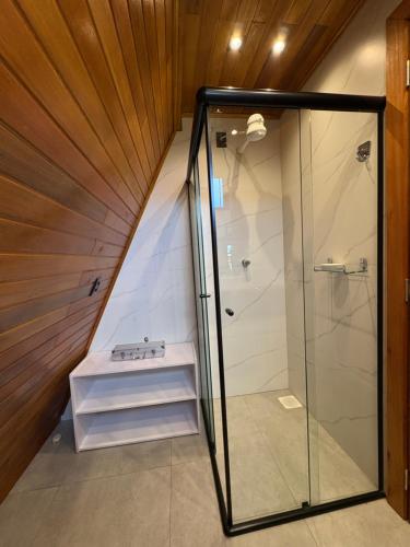 a bathroom with a walk in shower next to a staircase at Sítio das Amoreiras- Cabana in Tabapira