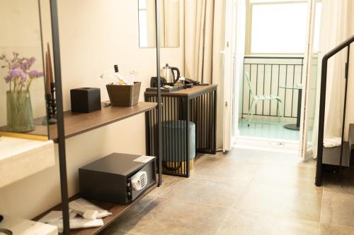 a room with a television on a floor with a balcony at ASO Hotel - Historic Raisin Warehouse 1928 in Kalamata