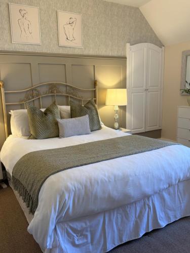 a bedroom with a large white bed with pillows at Antfield House in Inverness