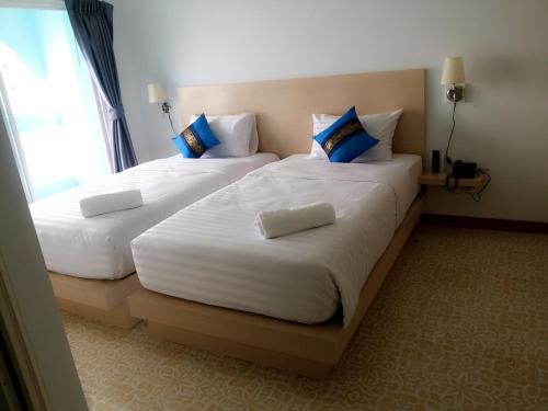 two beds in a hotel room next to a window at The Duck in Phuket Town